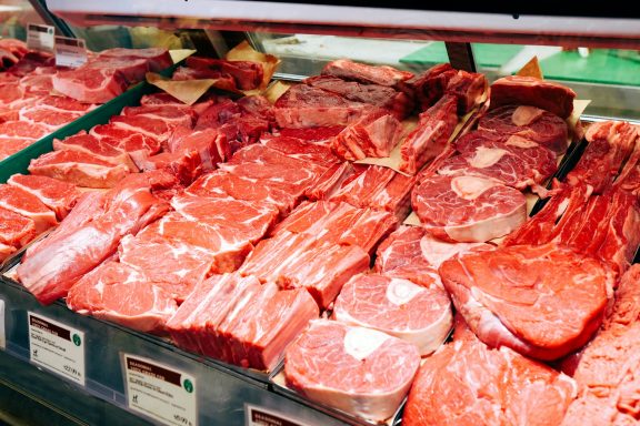 Assortiment de viandes rouges dans une vitrine de boucherie.