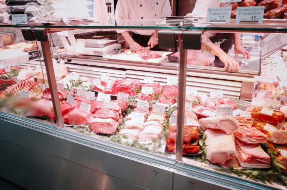 Vitrine d'une boucherie avec divers types de viandes fraîchement présentées.